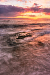 Warm summer sunset seascape with rock and waves on foreground and a colourful cloudy sky on background, Colour Photo, Figueira da Foz, Portugal