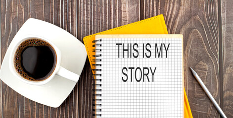 THIS IS MY STORY text on the notebook with coffee on wooden background
