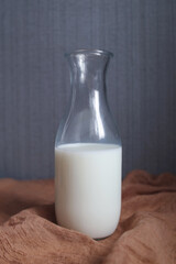 Glass bottle of milk. Gray background, brown fabric