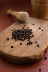 Black peppercorns and ground on a wooden board. Concept: spices, black pepper.