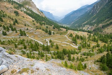 Fototapeta na wymiar Das Tal Vallone del Preit mit den Serpentinen der Passstraße, welche Teil einer beliebten Mountainbike Strecke ist - Cottische Alpen, Piemont