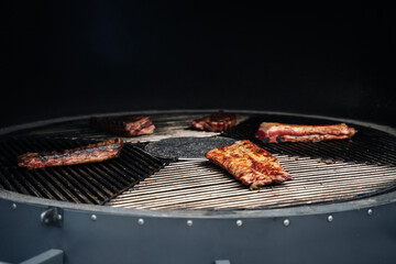 Several succulent pork ribs lie on the roaster's automatic, rotating grill grate