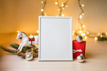 Portrait white picture frame mockup on table with boken lights and christmas decoration