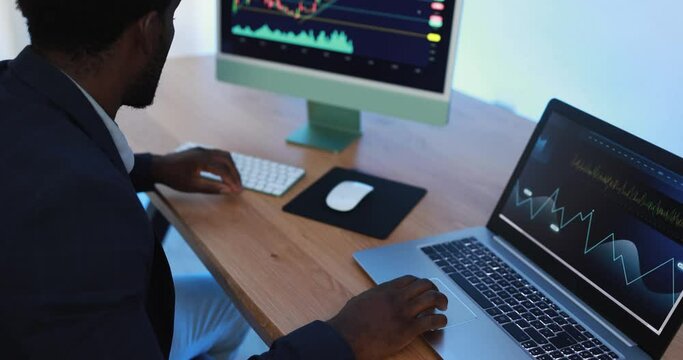 Business trader african man working inside fintech company office doing stock market research - Trading and technology concept