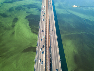 South bridge in Kiev. Algae bloom in the water of the Dnieper River. Aerial drone view.
