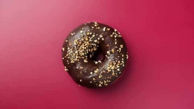 Tasty chocolate donut rotating at pink background. Delicious donut. Bakery and food concept. Glazed sweet dessert. 4K, UHD