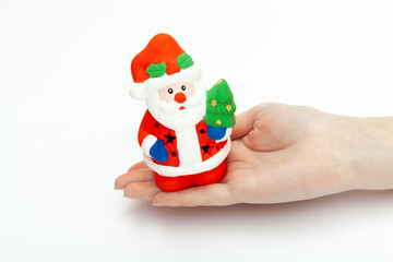 Little Santa Claus toy on the woman's hand isolated on white background. christmas and new year concept