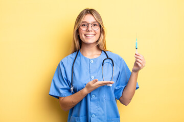 pretty blonde girl smiling cheerfully, feeling happy and showing a concept. nurse an vaccine concept - obrazy, fototapety, plakaty