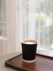 Hot cappuccino cup with heart shape latte art on table in coffee shop. Coffee lover concept