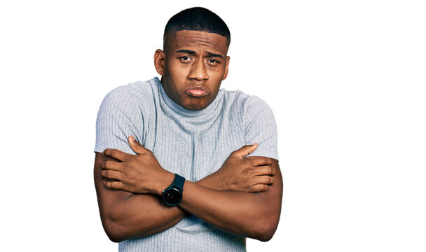 Young black man wearing casual t shirt shaking and freezing for winter cold with sad and shock expression on face