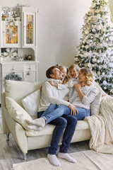 Happy young father mother and baby boy in christmas decorated studio