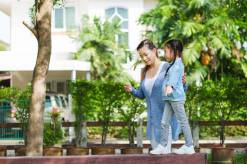 Happy asian family single mom and small daughter in the Park