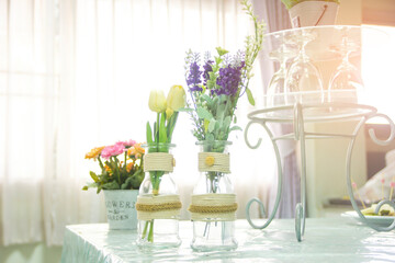 Artificial flowers in pots are placed on the dining table.