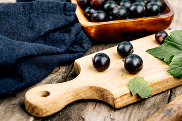 Fresh black currant. A handful of berries on a wooden table
