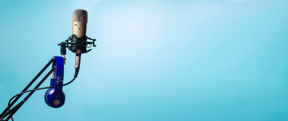 Blue bluetooth headphones with condenser microphone on stand.