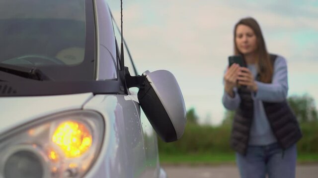 Woman driver with mobile phone takes photo in parking car accident broken mirror