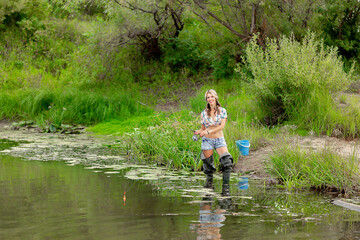Naklejka na ściany i meble fishing on the river, beautiful girl is fishing with a fishing rod