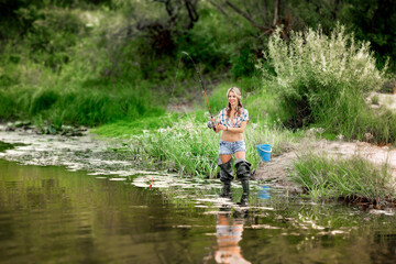 Fototapeta na wymiar fishing on the river, beautiful girl is fishing with a fishing rod
