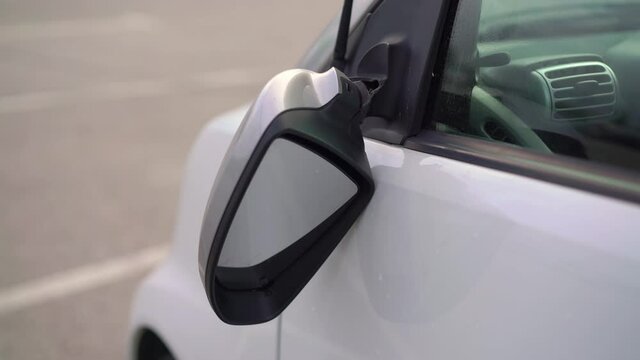 Broken off side rearview mirror on car. White automobile on road after accident.