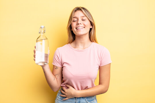 pretty blonde girl laughing out loud at some hilarious joke. water bottle concept