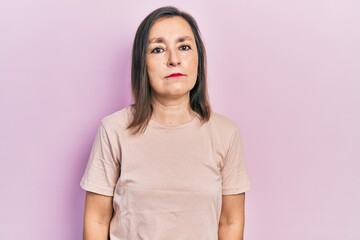 Middle age hispanic woman wearing casual clothes relaxed with serious expression on face. simple and natural looking at the camera.