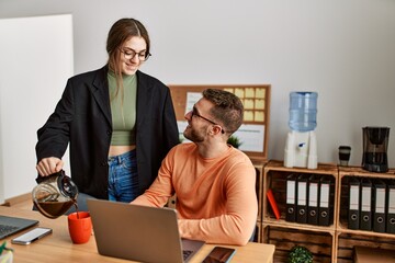 Two caucasian business executives working and drinking coffee at the office.