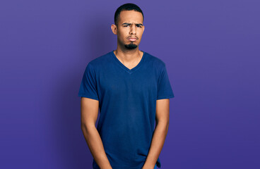 Young african american man wearing casual t shirt skeptic and nervous, frowning upset because of problem. negative person.