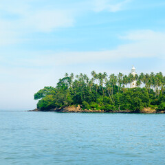 Fototapeta na wymiar Lighthouse and turquoise ocean . Sri Lanka . Concept - vacation and travel.