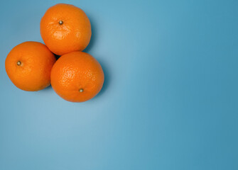 Fresh yellow oranges from the fields on a blue background