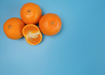 Fresh yellow oranges from the fields on a blue background