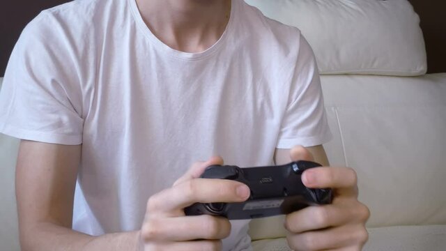 Three Quarter View of young unrecognizable adult man playing videogames