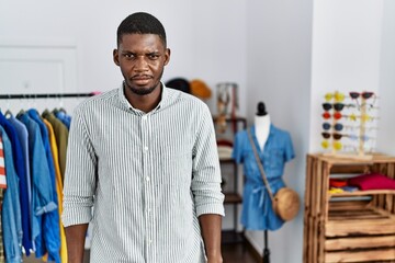 Young african american man working as manager at retail boutique skeptic and nervous, frowning upset because of problem. negative person.