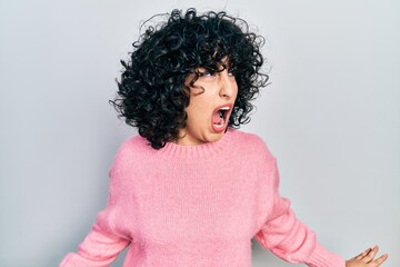 Young middle east woman wearing casual clothes angry and mad screaming frustrated and furious, shouting with anger. rage and aggressive concept.