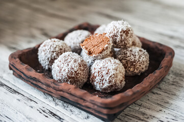 Homemade truffle candies in coconut flakes close-up and copy space...