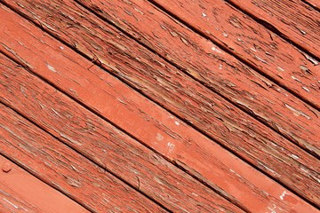 Texture of planks of old wood with peeling red paint
