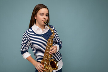 Shot of pretty positive happy brunet little lady wearing stylish striped longsleeve standing...