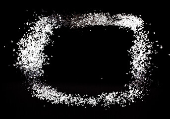 White and silver metallic sequins on a black background.