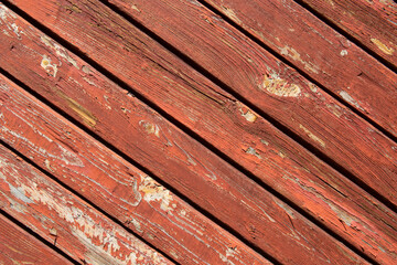 Texture of planks of old wood with peeling red paint