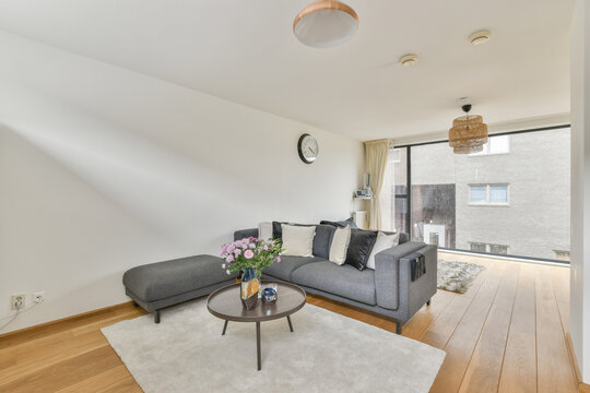 Modern room interior with sofa against flowers on table