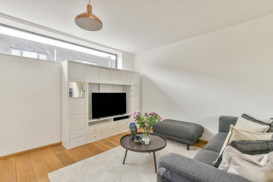 Modern room interior with sofa against flowers on table
