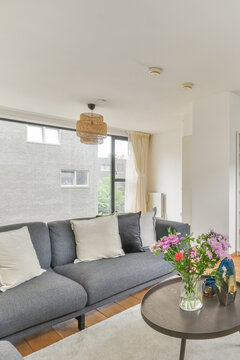 Modern room interior with sofa against flowers on table