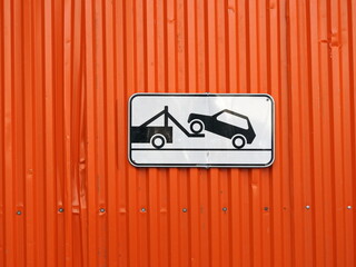 Traffic sign - tow truck on an orange background.