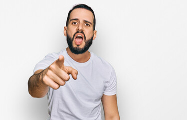 Fototapeta premium Young man with beard wearing casual white t shirt pointing displeased and frustrated to the camera, angry and furious with you
