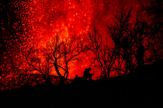Human silhouette sitting against exploding lava in La Palma Canary Islands 2021
