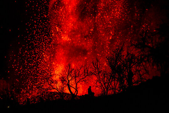 Human silhouette sitting against exploding lava in La Palma Canary Islands 2021