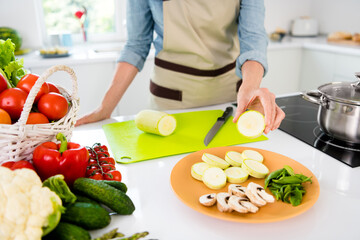 Obraz na płótnie Canvas Cropped photo of mature funky lady put zucchini wear apron jeans shirt at kitchen alone