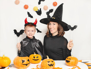 Fototapeta premium Mother and son have fun and celebrate Halloween in a witch and devil costume. Happy Family celebrating for Halloween
