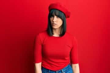 Naklejka premium Young hispanic woman wearing french look with beret skeptic and nervous, frowning upset because of problem. negative person.