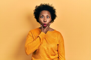 Fototapeta na wymiar Young african american woman wearing casual clothes looking fascinated with disbelief, surprise and amazed expression with hands on chin