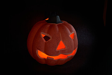 A glowing carved pumpkin in a black background - halloween concept